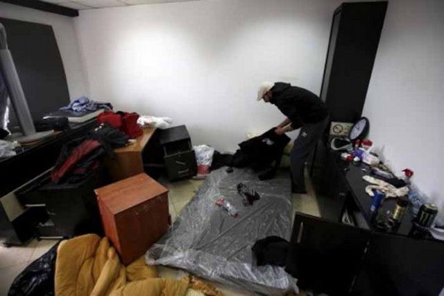 Palestinian man inspects the damage following a raid by Israeli forces on Palestine Today TV station in the West Bank city of Ramallah
