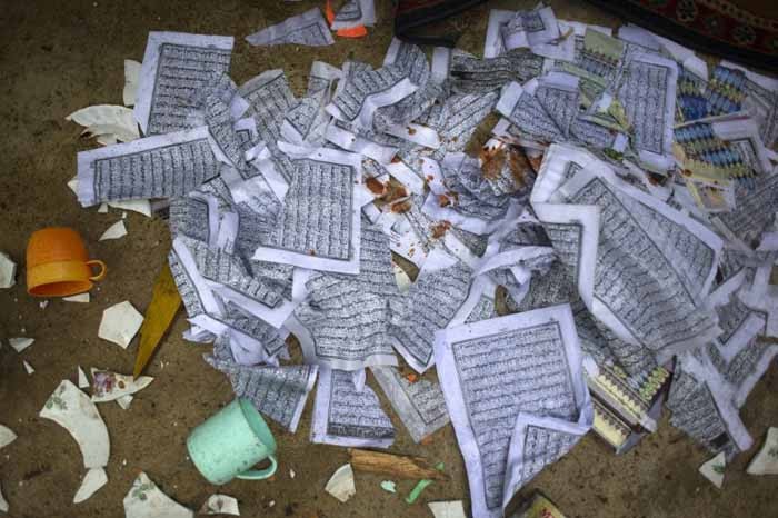 Religious papers lie on the floor inside the destroyed mosque at Thuye Tha Mein village in Bago province on June 24, 2016, after violence erupted on June 23 when a mob of around 200 Buddhists rampaged through the area following an argument between neighbours over the building of a Muslim school. Scores of Buddhists ransacked a mosque in central Myanmar forcing Muslims to seek refuge overnight in a police station after a dispute between neighbours spilled into religious violence, officials and residents said on June 24. / AFP PHOTO / YE AUNG THU